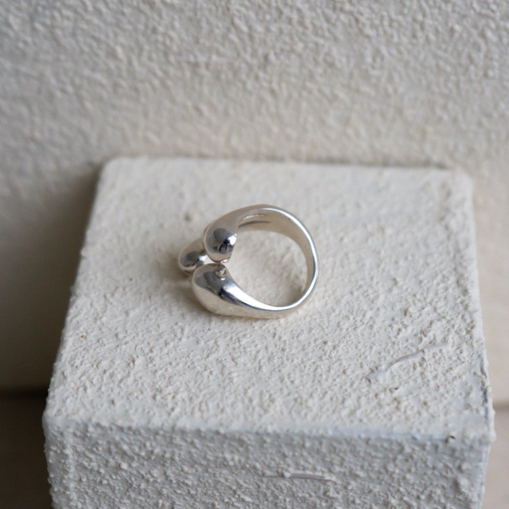 Silver ring on a white cube with a plain background